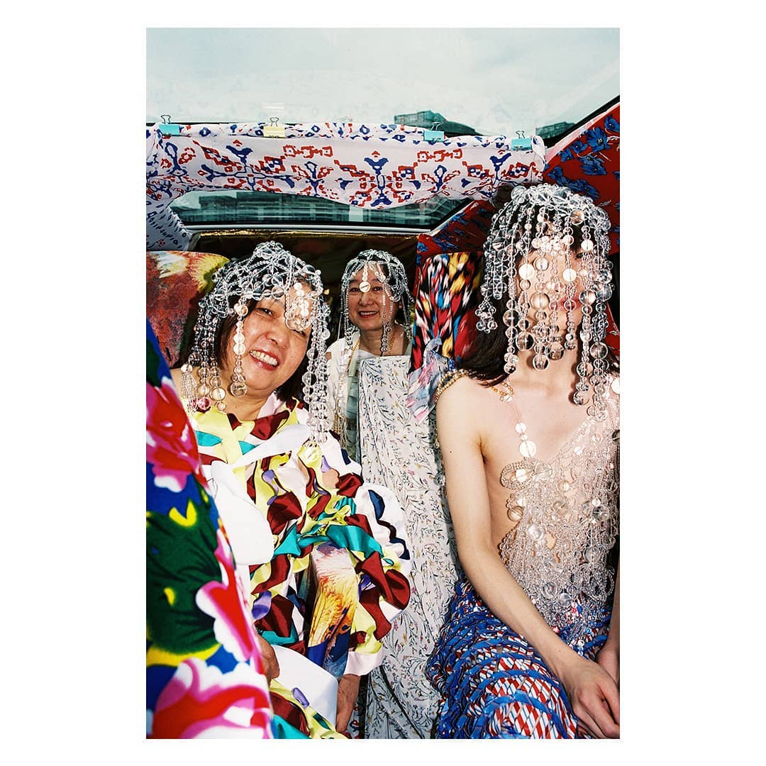 femmes dans une voiture entourée de papier peint multicolore par Hubert Crabieres 