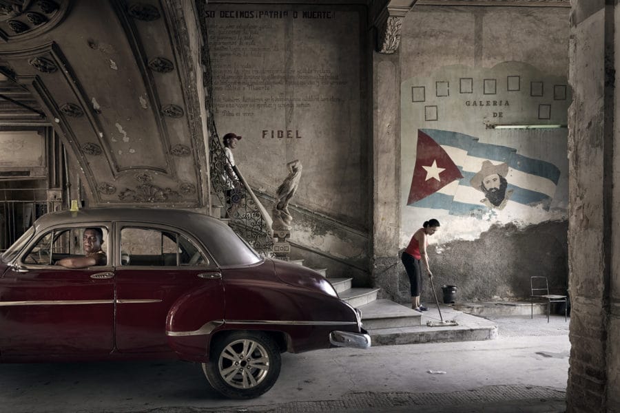 taxi cubain sous un pont avec une peinture murale  Havana Taxi Company