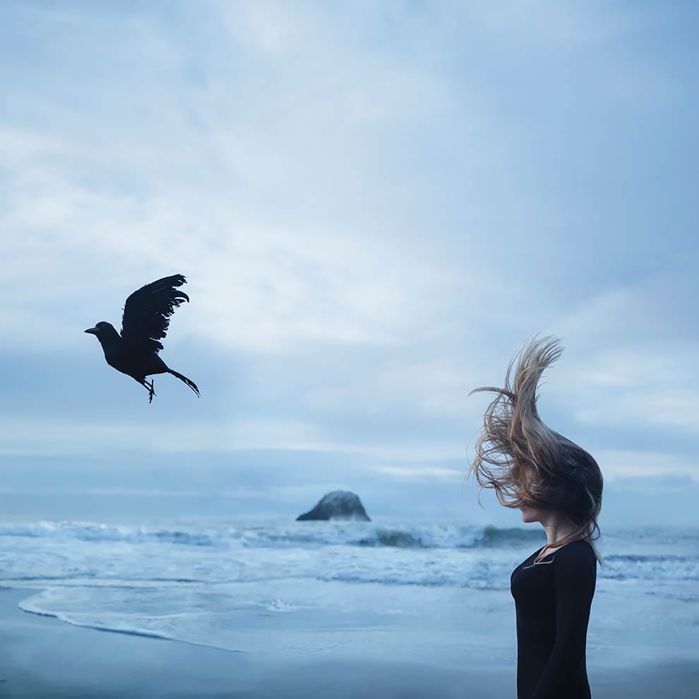 modèle les cheveux au vent qui regarde un corbeau s'envoler 