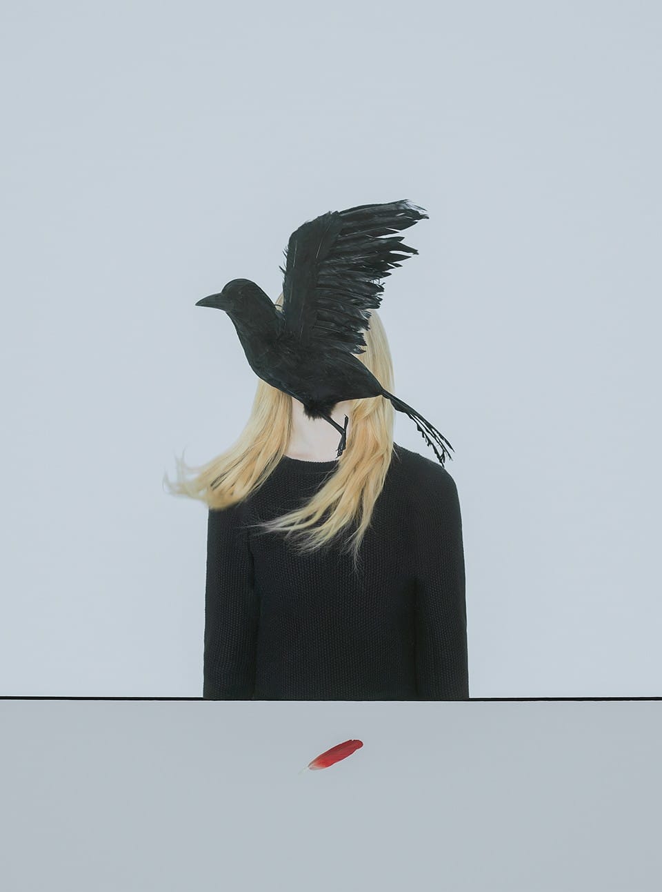 photo de Gabriel Isak qui montre un corbeau en plein vol qui cache le visage d'une modèle 
