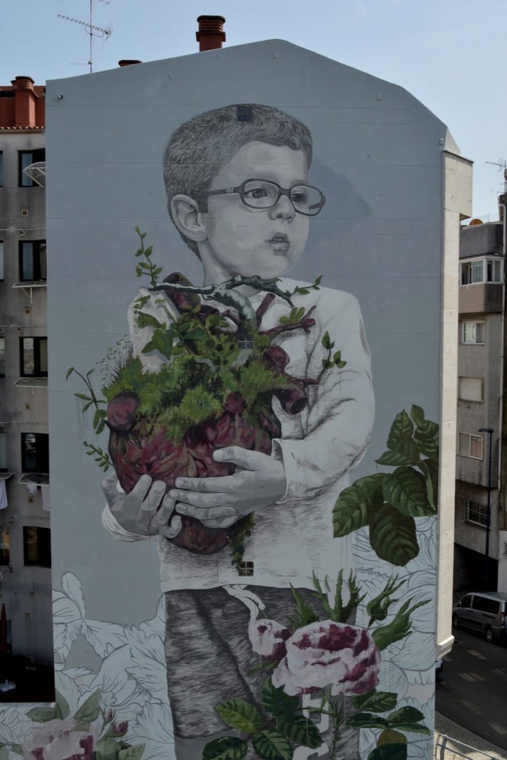 un enfant portant le cœur de la nature, street art