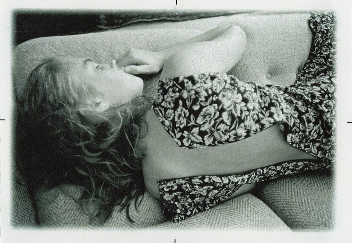 Jenny Rova allongée sur un canapé, robe à fleurs