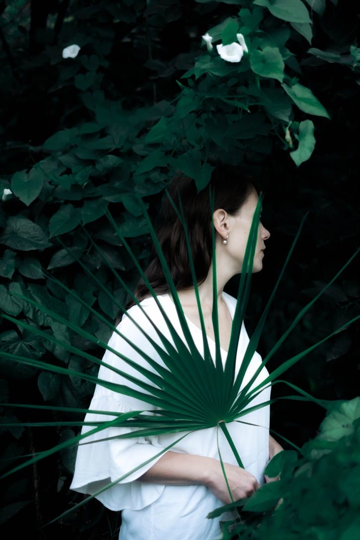 Photographie réalisée par Polina Washington illustrant un portrait de femme avec des feuilles