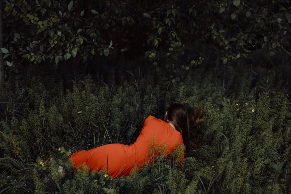 Photographie réalisée par Polina Washington illustrant une fille étendue dans l'herbe