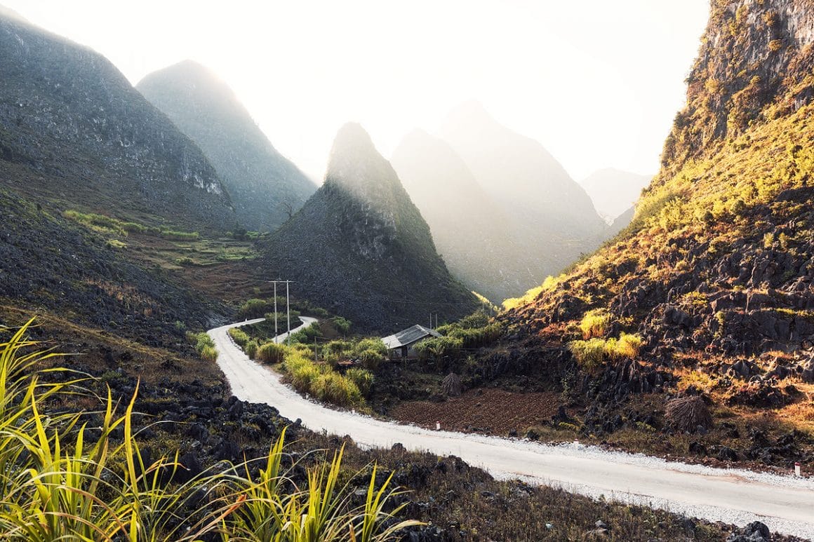Voici une des impressionnantes photographies de Lukas Furlan :
Vue sur une petite route qui traverse des montagnes, une partie de la photographie est éclairée par la lumière du soleil.