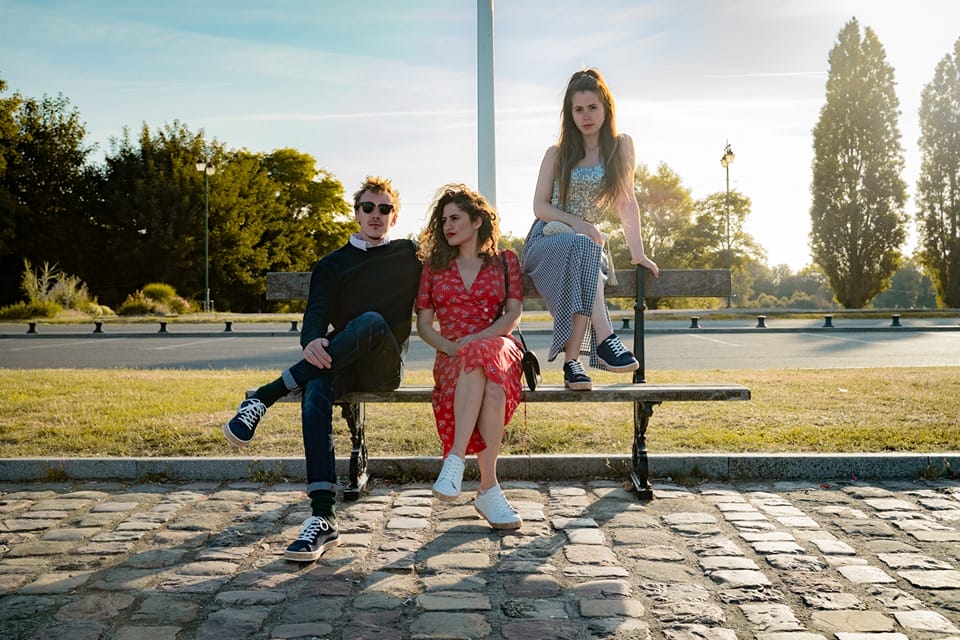 Trois personnes assises sur un banc et portant les sneakers Marcel & Simone