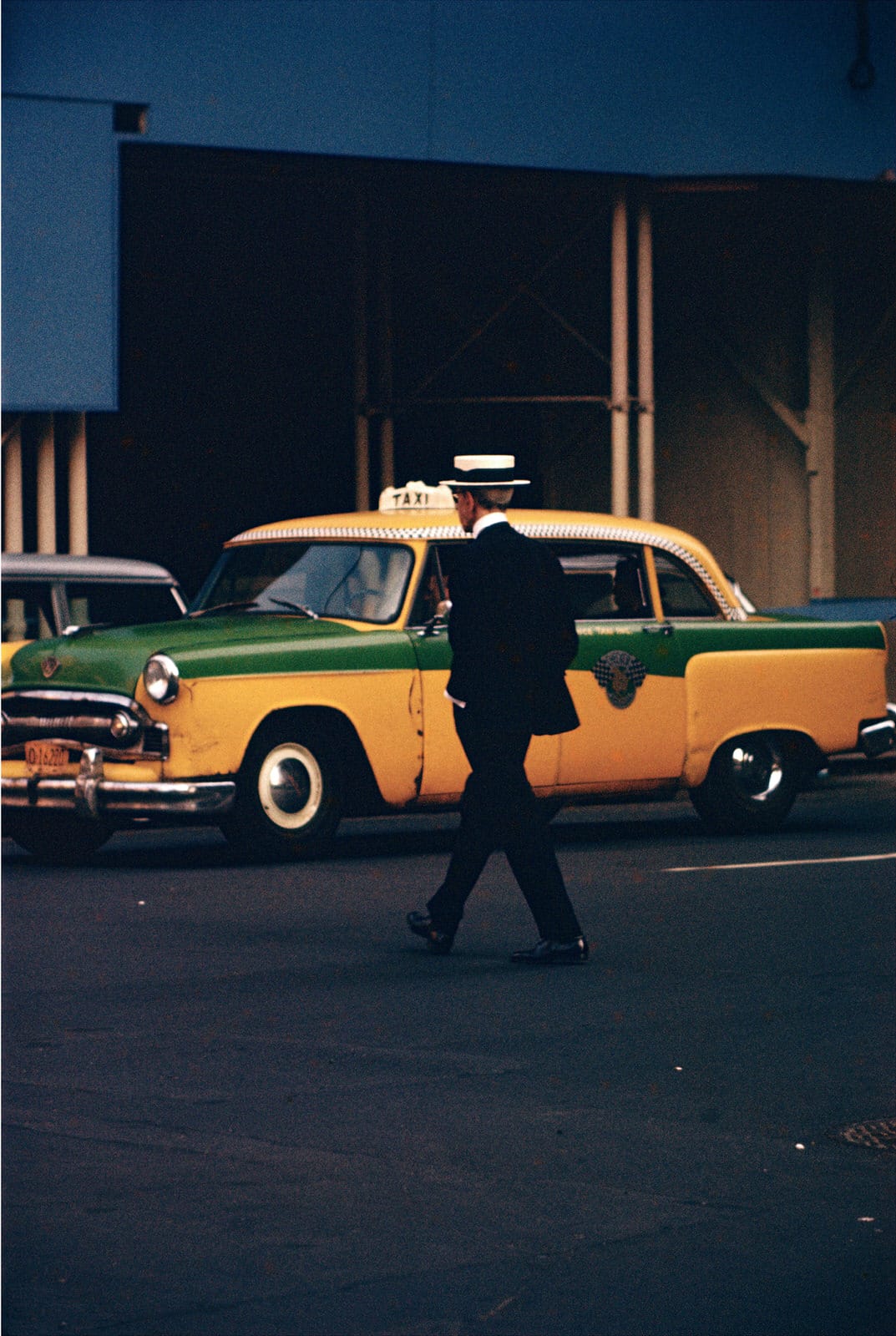 Photographie Saul Leiter, homme traversant devant un taxi
