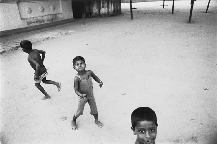 Roger Ballen, 3 enfants dans une cour en train de jouer. 