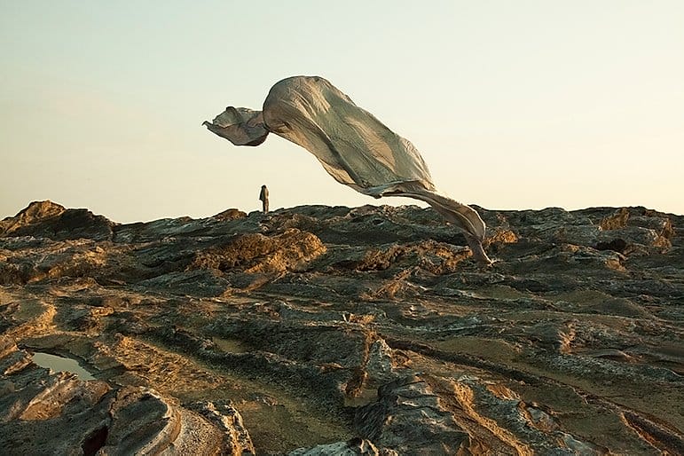 Yoshiki Hase, un tissu au vent devant un paysage désertique. 