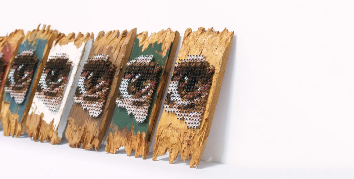 Aheneah, plusieurs panneaux de bois avec des yeux brodés. 