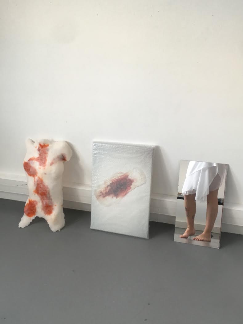 trois oeuvre, sculpture d'un corps, photo d'une serviette hygiénique, miroir