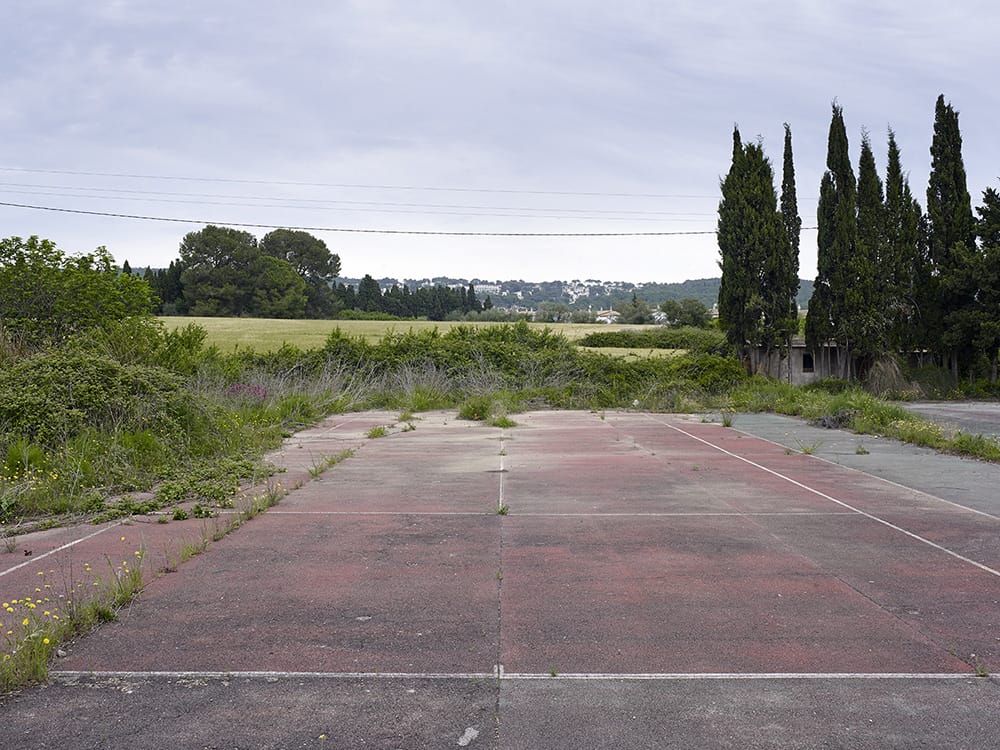 Guillem Vidal lieu abandonné terrain tennis rouge goudron sapin