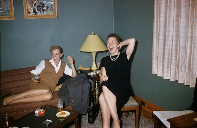 deux femmes salon canapé robes rigolent 
