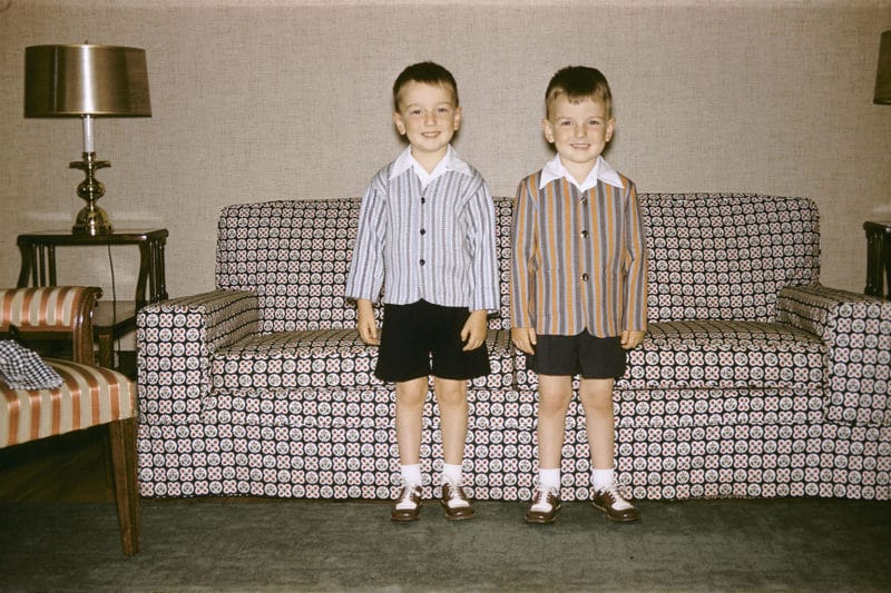 canapé motifs jumeaux garçons debout chemises short noirs chaussettes blanches 