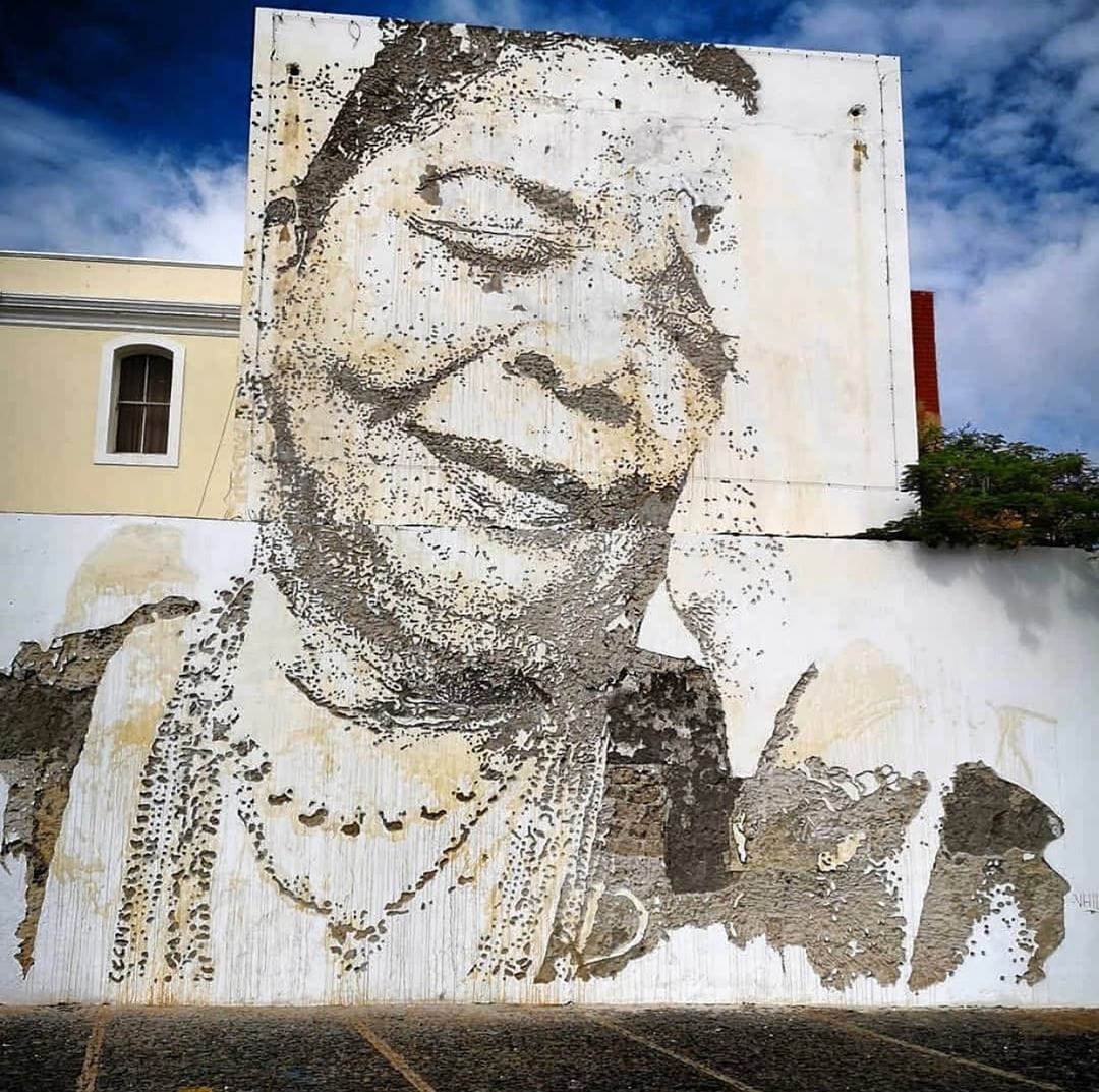 femme africaine colliers maison blanche ciel bleu gravure mur 