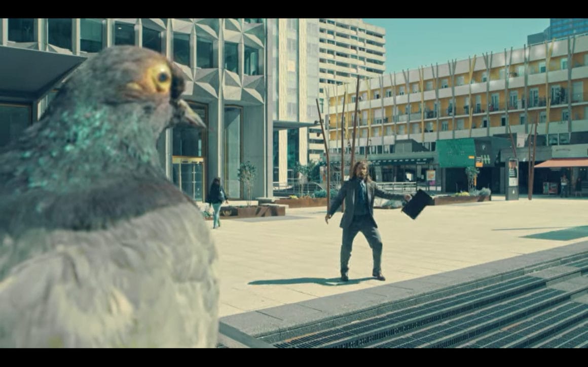 Capture d'écran de la rencontre entre un employé terrorisé et un pigeon, dans le clip de The Supermen Lovers