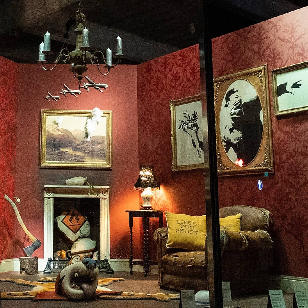 Photo de la boutique éphémère de Banksy, des tableaux, un fauteuil abimé et divers ojets