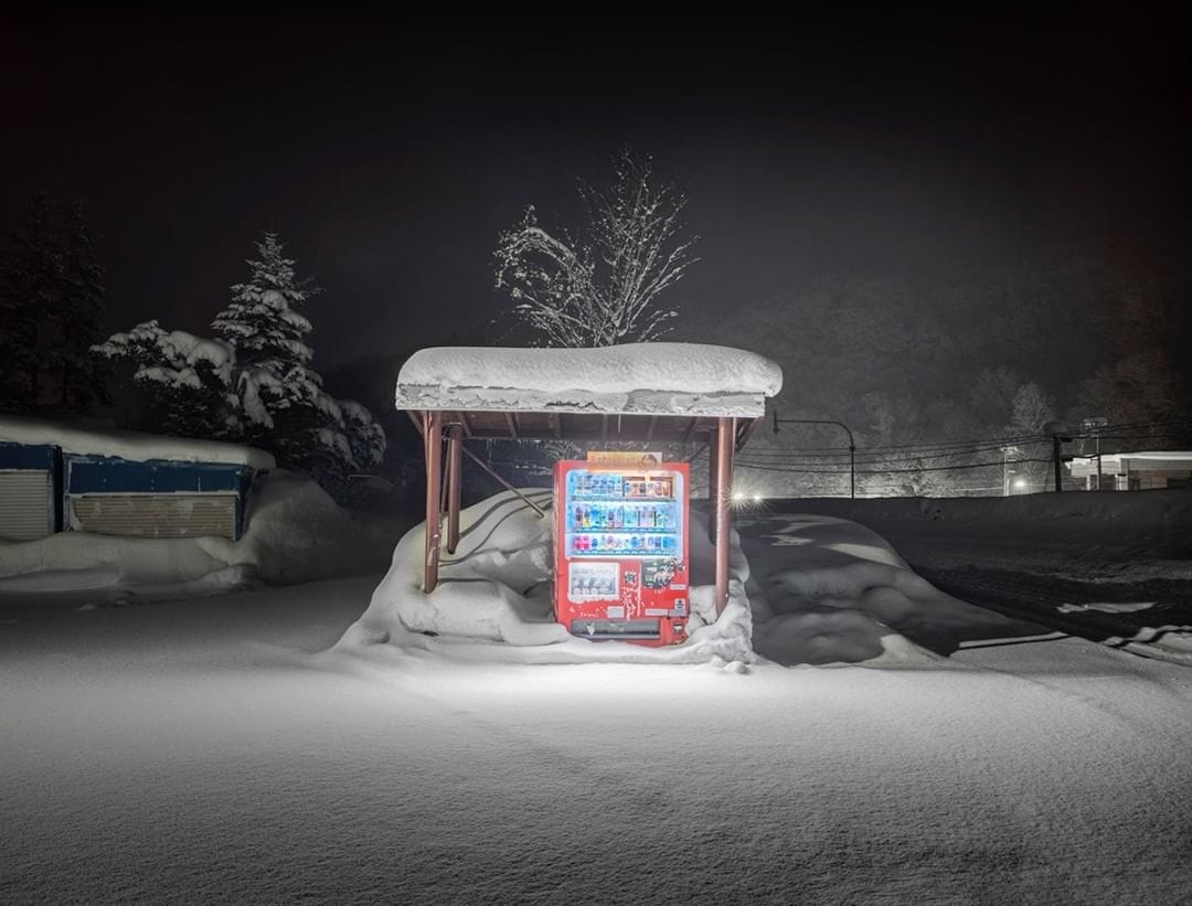 Un distributeur sous un abri bus qui le protège de la neige