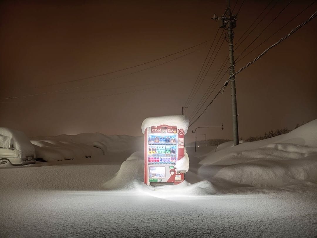 Un parking sous la neige, seul le distributeur semble y résister