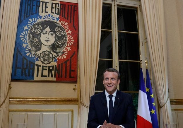 Emmanuel Macron avec au fond accroché au mur la fresque Marianne d'Obey