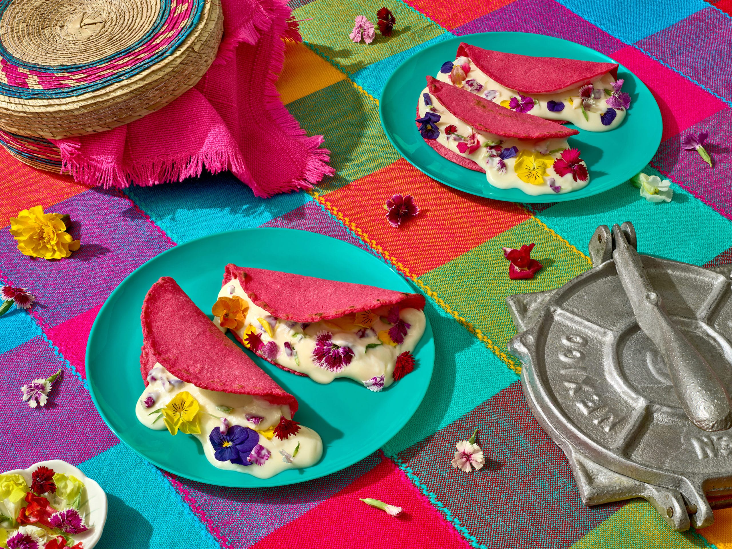 Assiettes de tacos roses dont sort une crème remplie de lfeurs