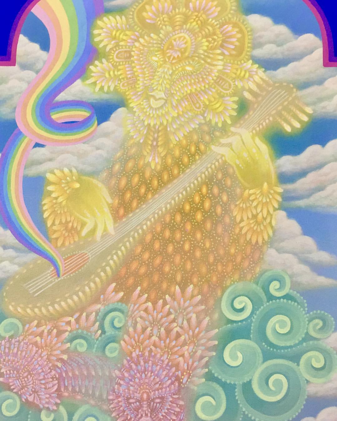Personnage doré au milieu des nuages qui joue d'un instrument dont s'échappe un arc en ciel