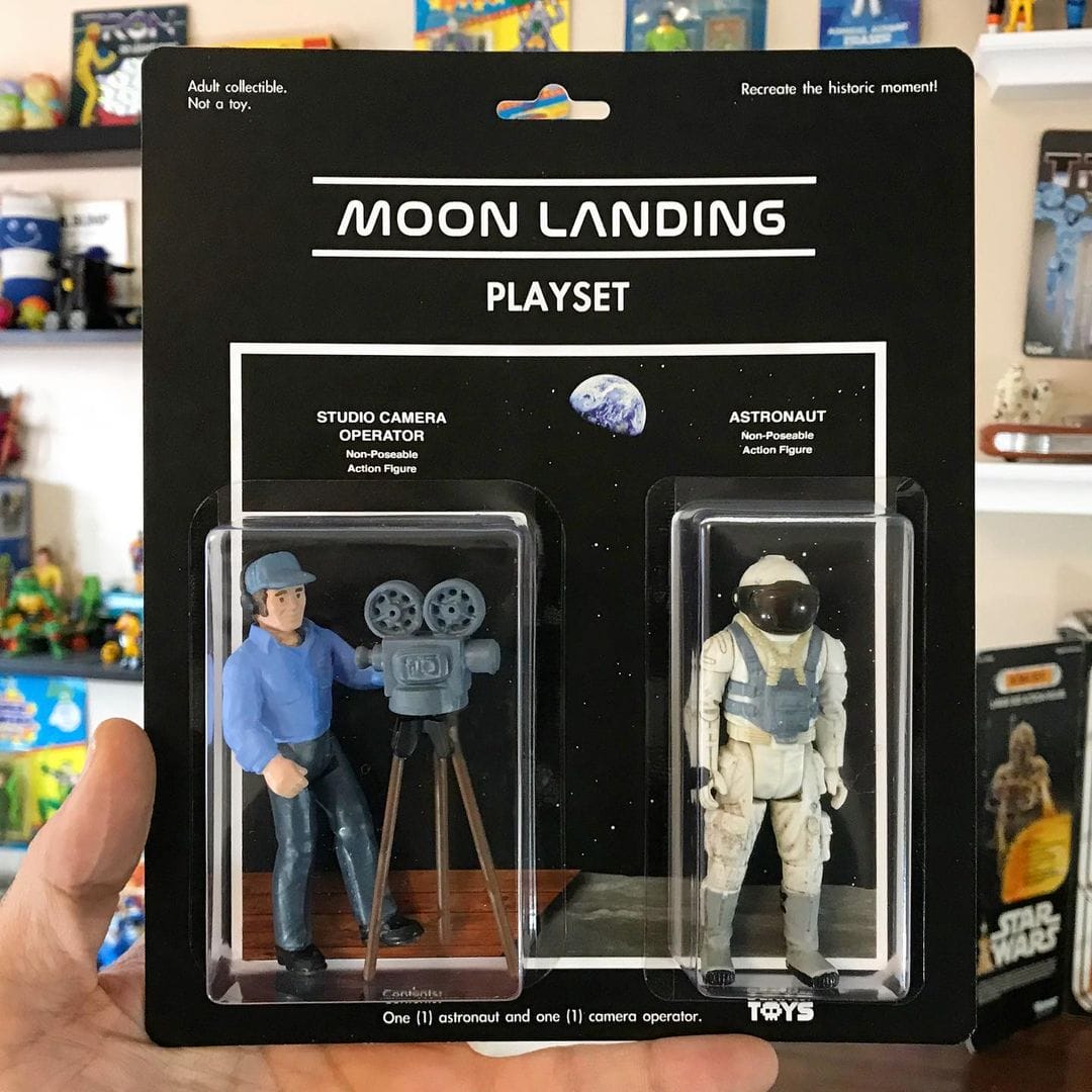 Deux figurines, un caméraman et un astronaute. Reprend la théorie du complot selon laquelle l'atterrissage sur la lune serait un hoax.