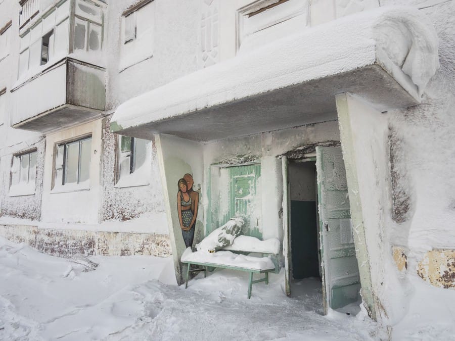 Une entrée d'un immeuble abandonné blanche de neige et de glace