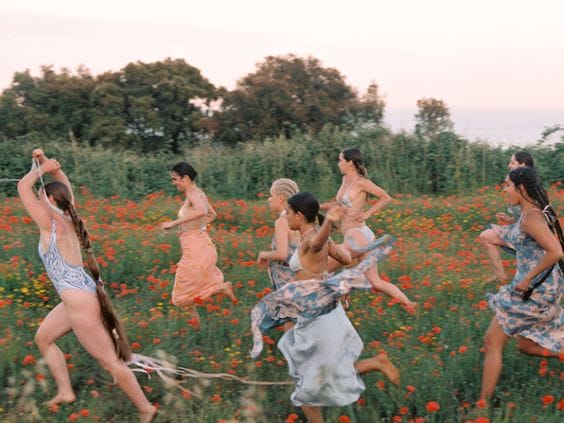 femmes qui courent dans un champ, fleurs rouges