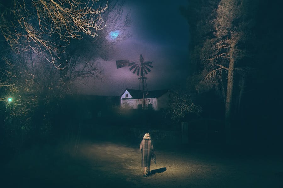Sur cette oeuvre d'Henri Prestes, on peut voir une femme en premier plan de dos, marchant vers une maison dans la nuit