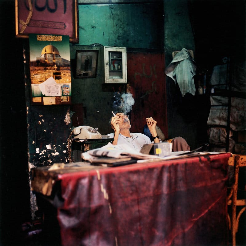 Photographie d'une vieil homme égyptien fumant.