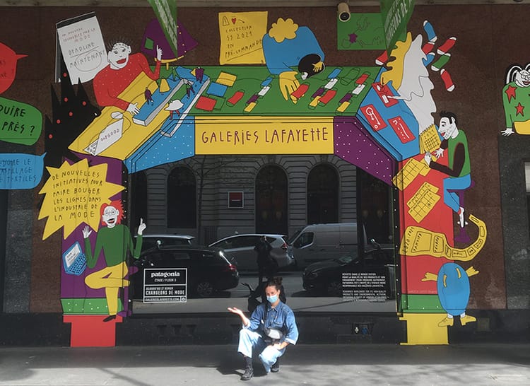 Photographie de Tamaya Sapey-Triomphe devant ses décors pour les galeries La Fayette.