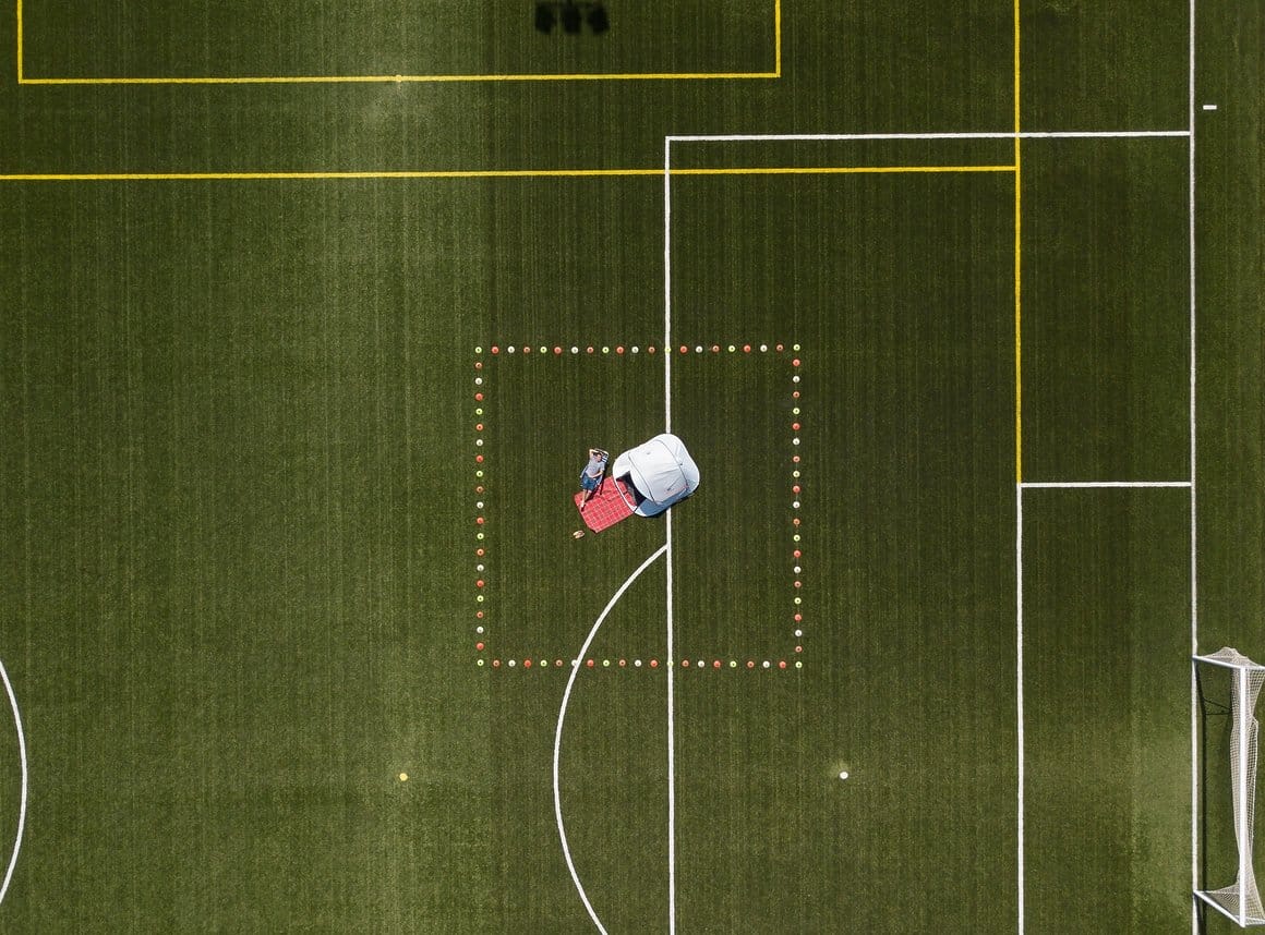 Photographie du dessus de Ruben Martin De Luca étendu sur un terrain de foot.