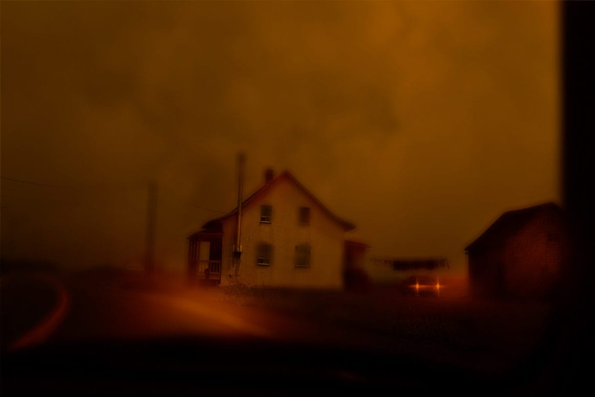 Photographie d'une maison isolée, l'atmosphère est floue et rouge.