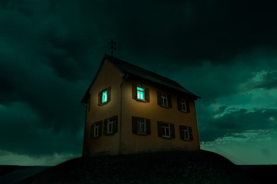 Photographie d'une maison sur une butte avec un ciel bleu.