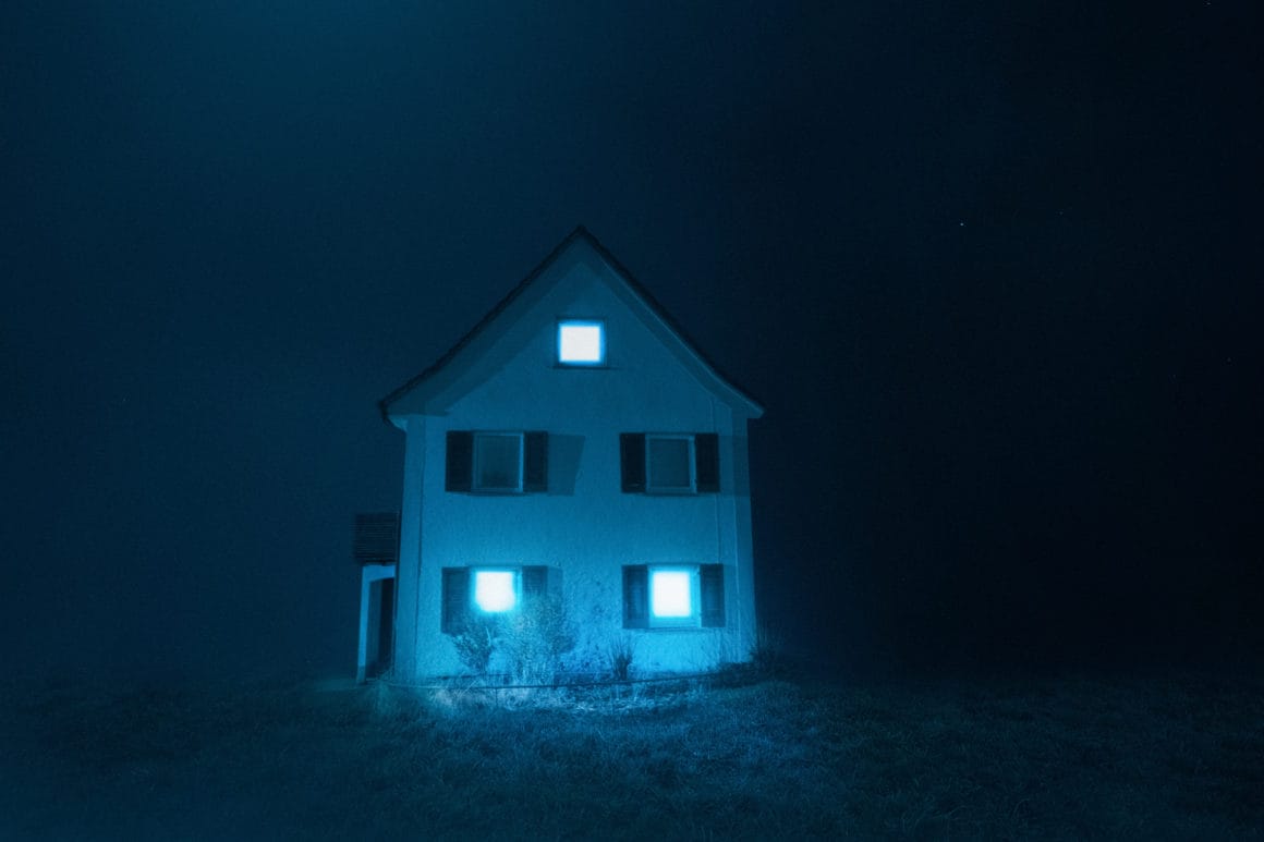 Photographie d'une maison isolée avec un ciel bleu.