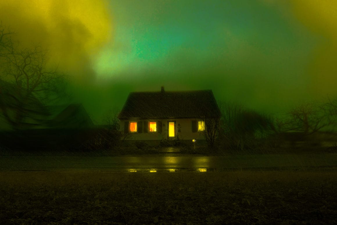 Photographie d'une maison isolée avec un ciel vert.