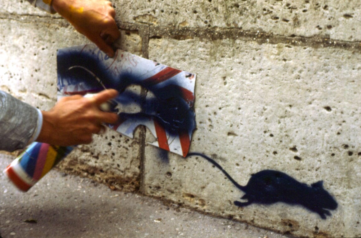 Blek Le rat peint un rat sur un mur à l'aide d'un pochoir 
