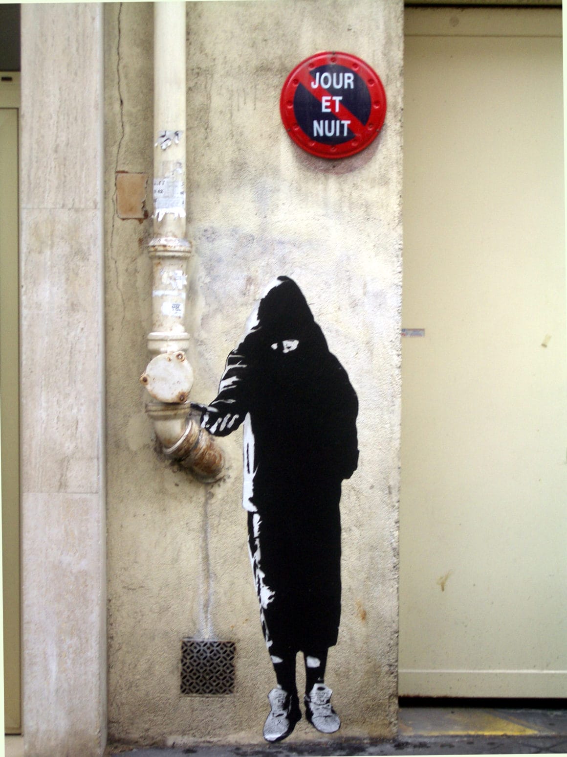 Un mendiant debout qui tend la main peint au pochoir sur un mur de Paris en 2005