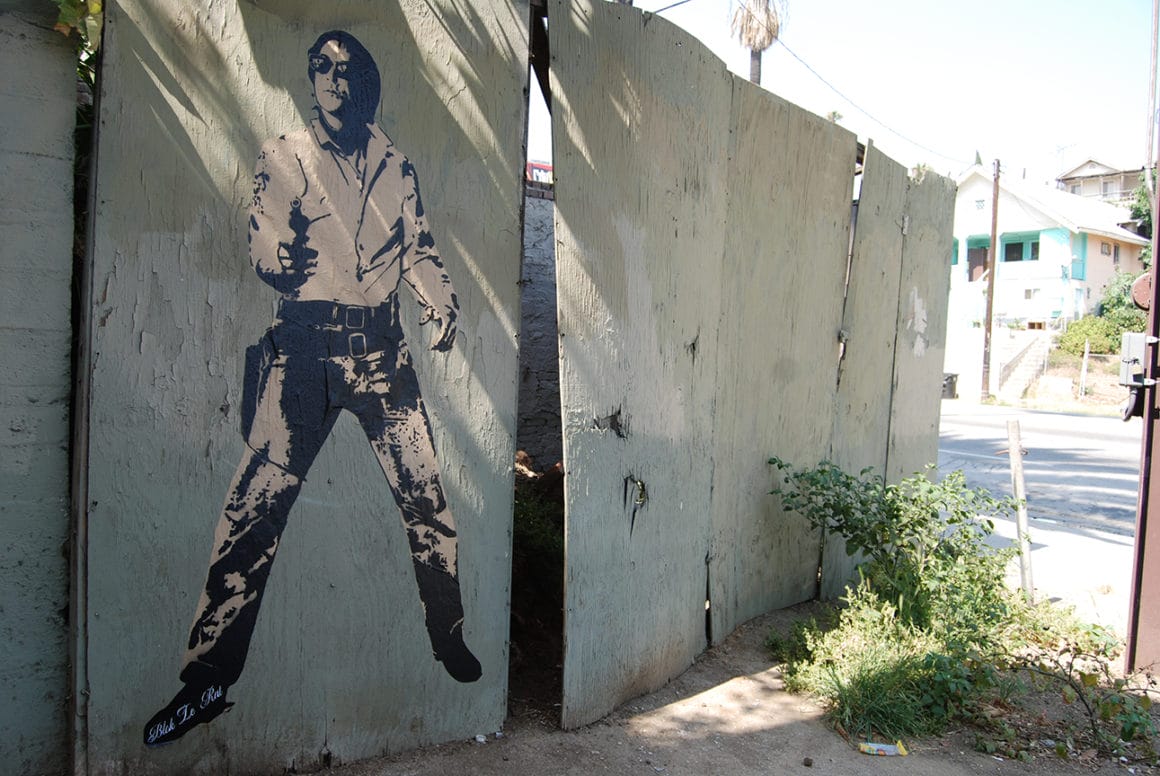 Blek Le Rat tenant une bombe de peinture à la main peint sur un mur de Sunset Boulevard en 2007