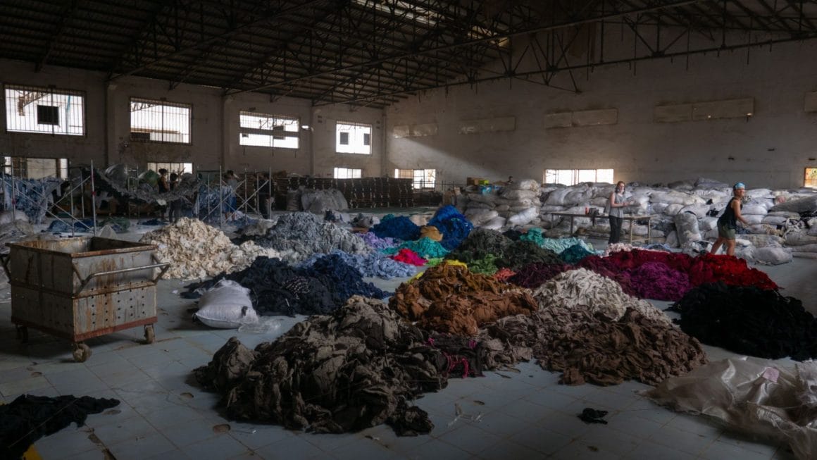 Un tas de vêtements colorés dans un entrepôt. 