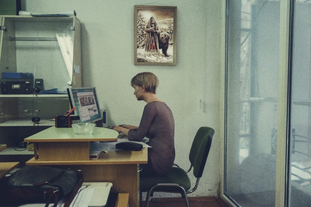 une femme est assise à un bureau sur son ordinateur 
