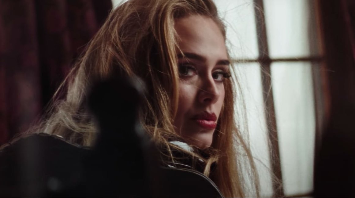 Portrait d'Adele qui regarde vers la caméra dans son clip "Easy On Me"