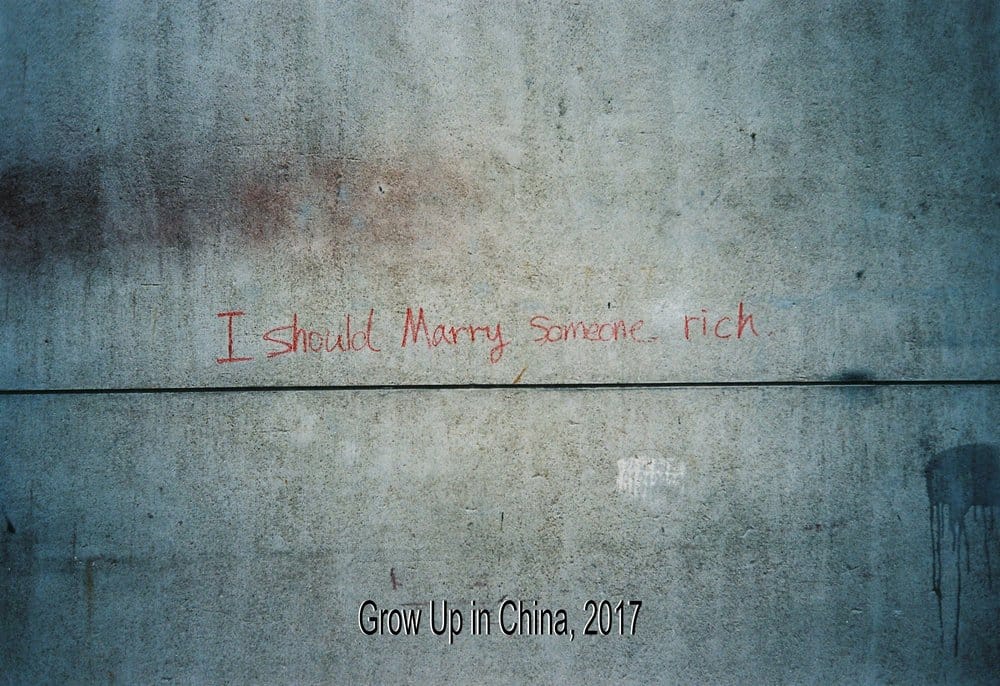 photo d'une écriture rouge sur un mur "I should marry someone rich"