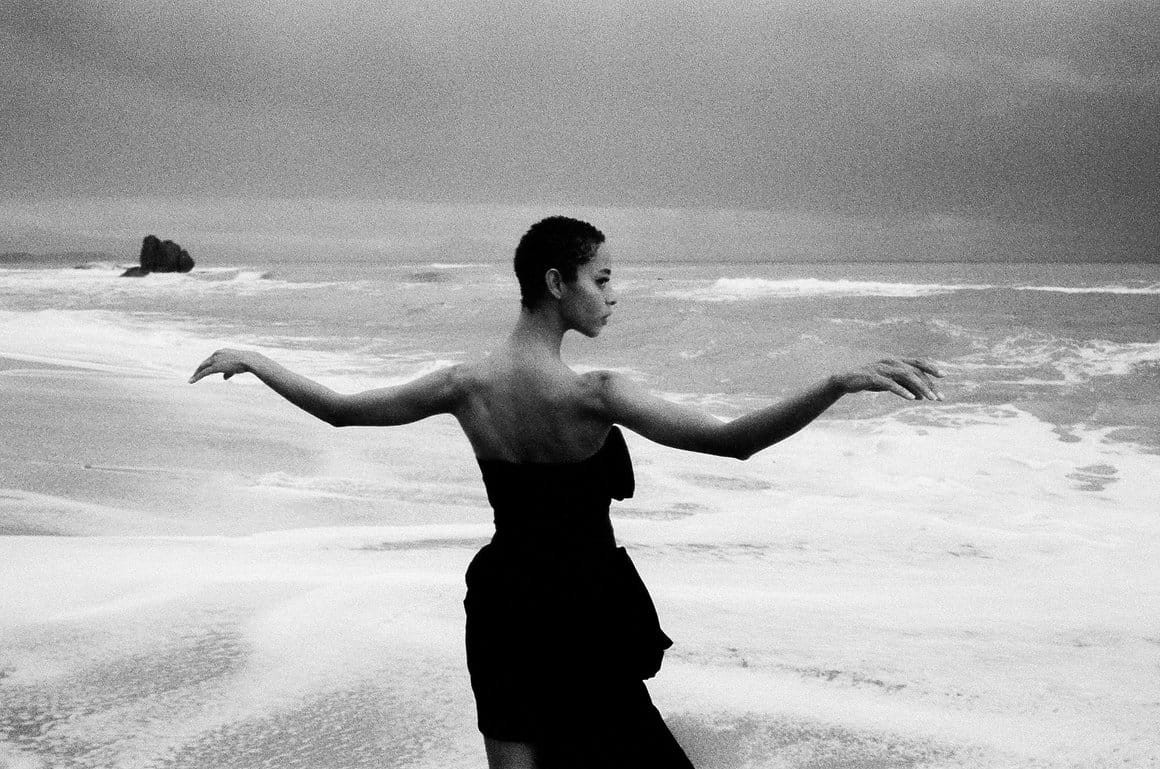 photo en noir et blanc de gilone face à l'océan, les bras déployés