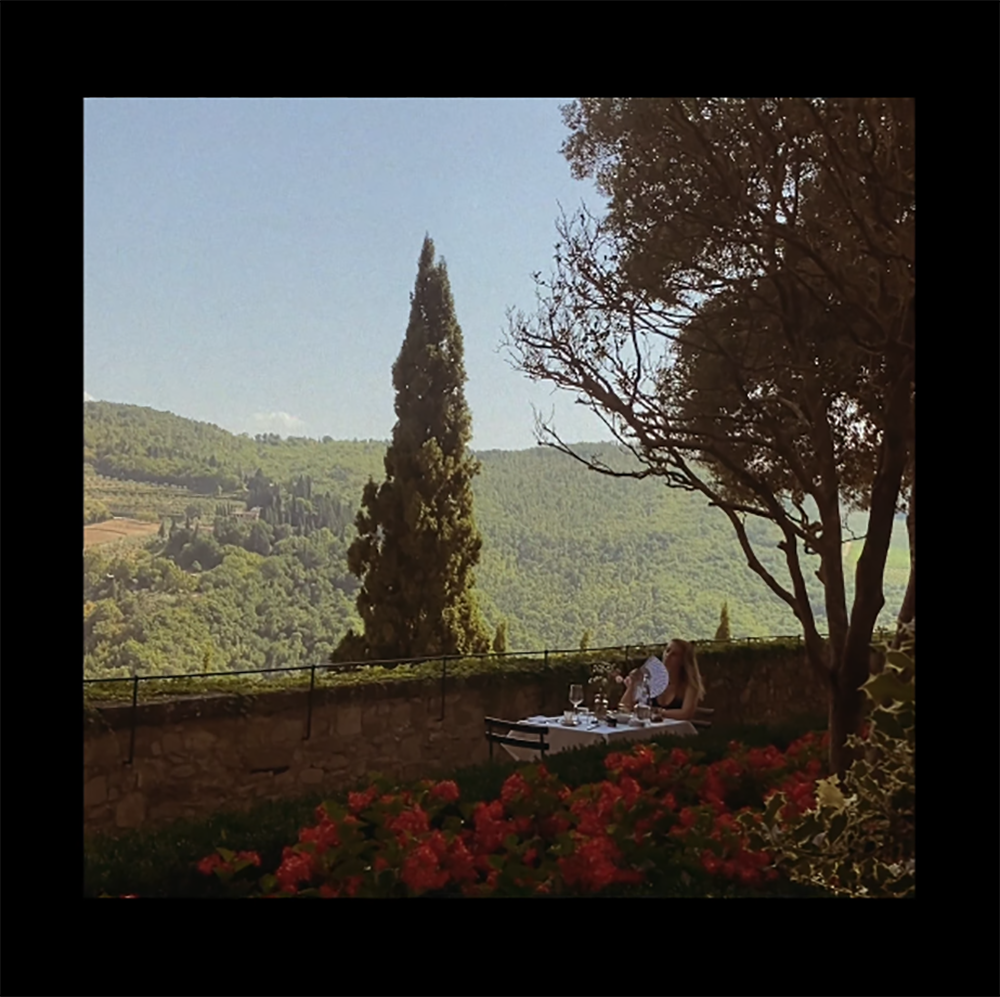 Capture d'écran clip "Emmène-moi" de Charlie Faron / Zoé est dehors en terrasse à table