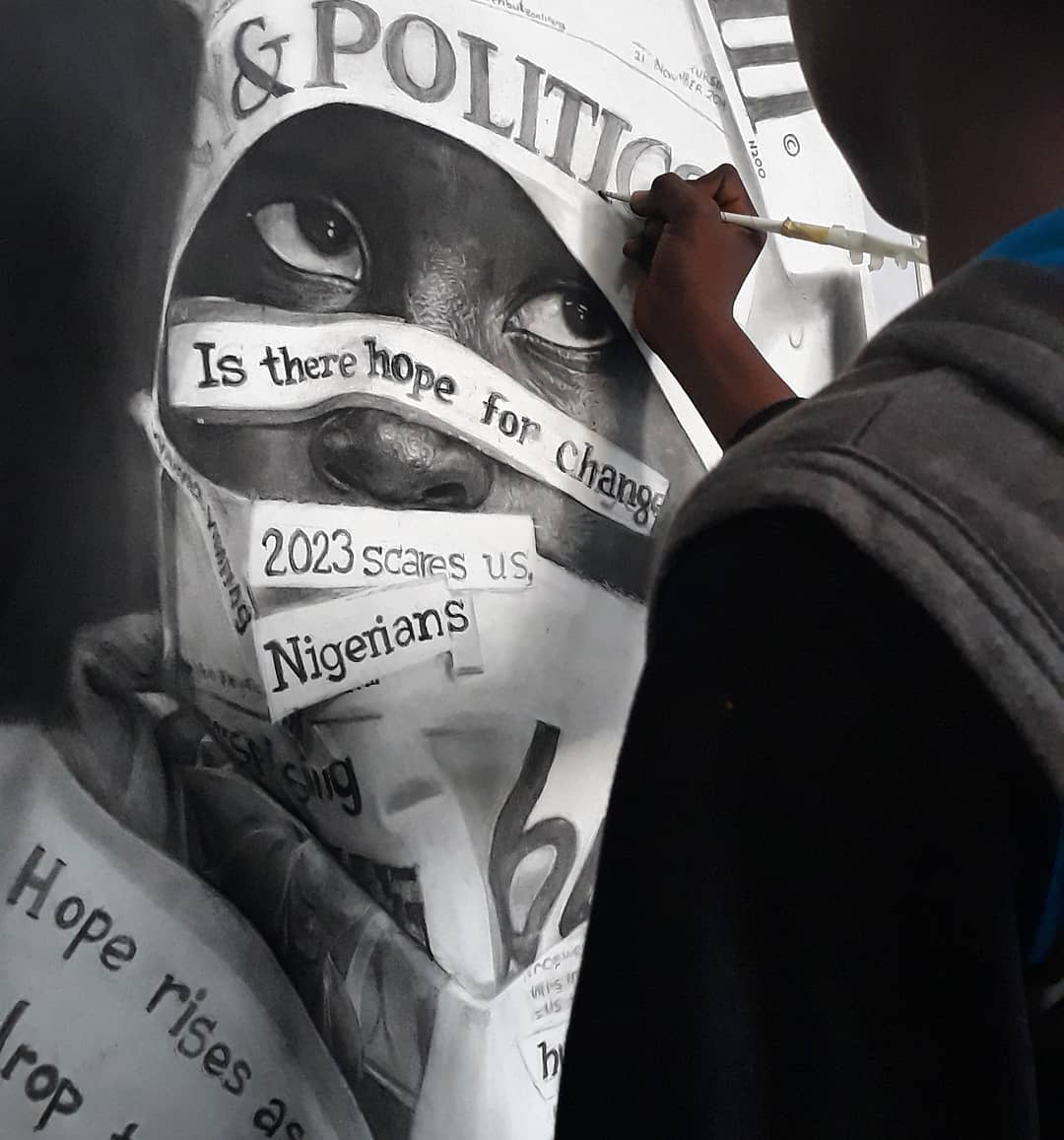 Photo de Waspa qui dessine un enfant avec des messages politiques sur le visage. 