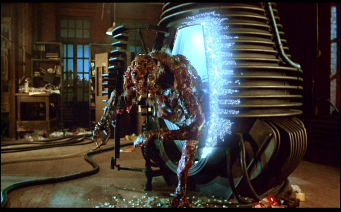 La créature sort de la machine dans le film "La Mouche" de David Cronenberg.