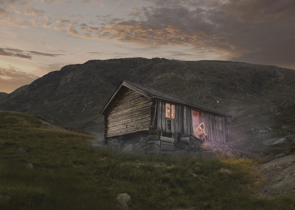 Maison en bois perdue dans les montagnes femme assise