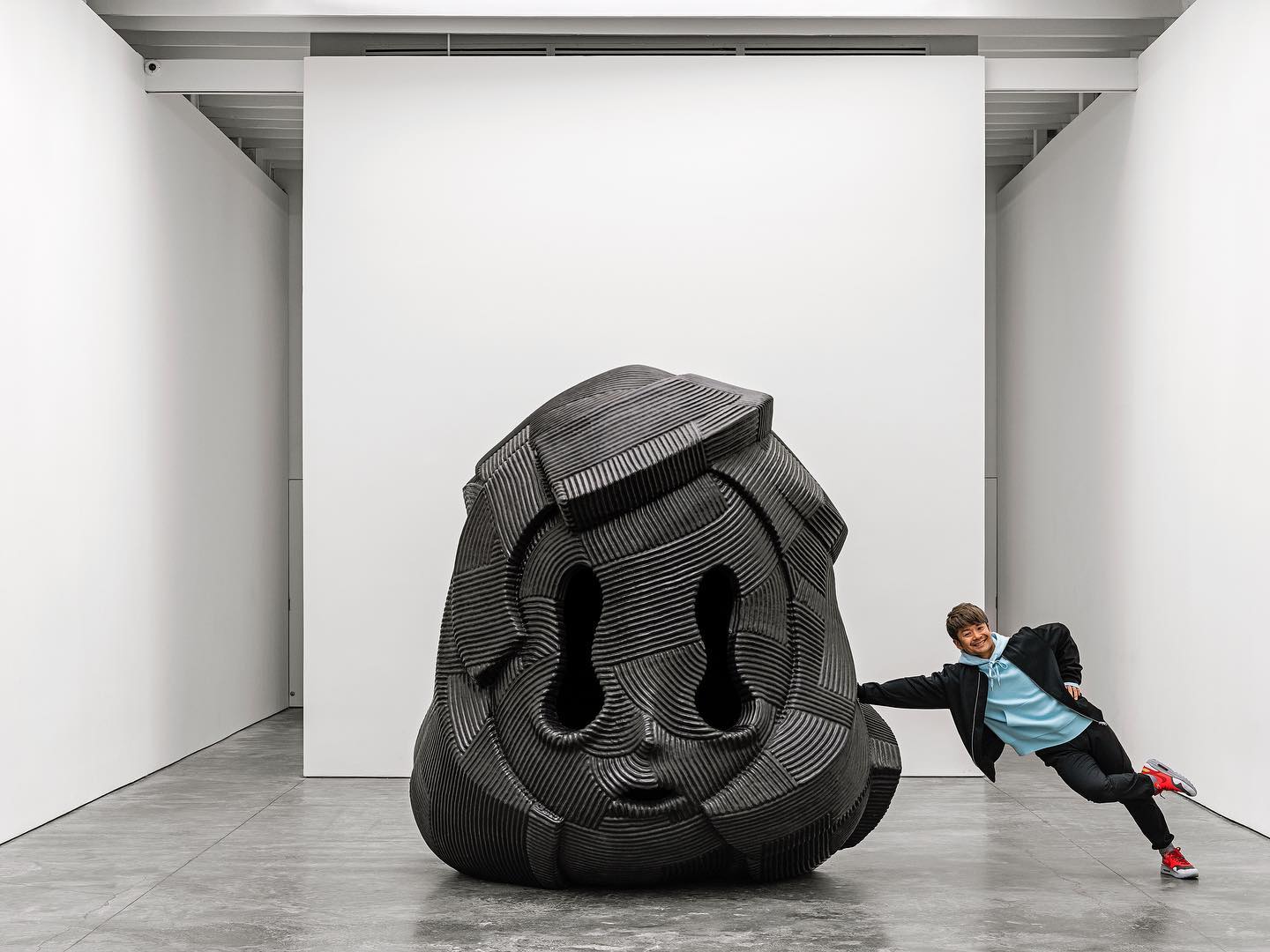 En Iwamura avec sculpture géante tête noire